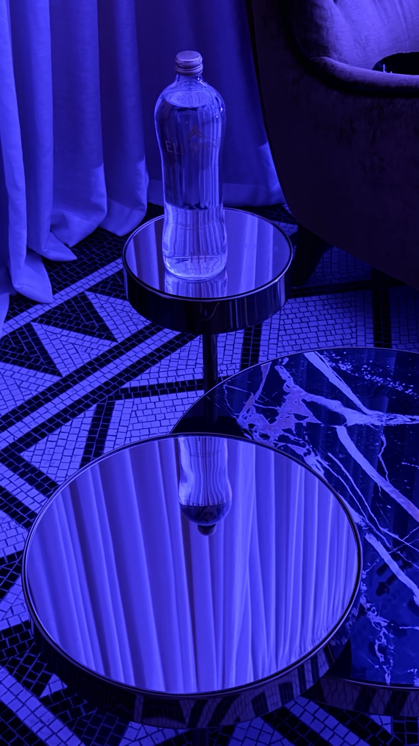 Original ELEVARE111 bottle photograph at Villa Bismarck in blue evening light, reflected in a mirrored table