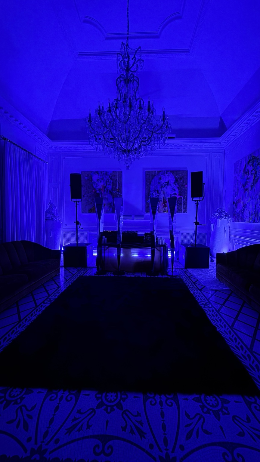Villa Bismarck salon lit blue for the private evening, with chandelier and patterned floor